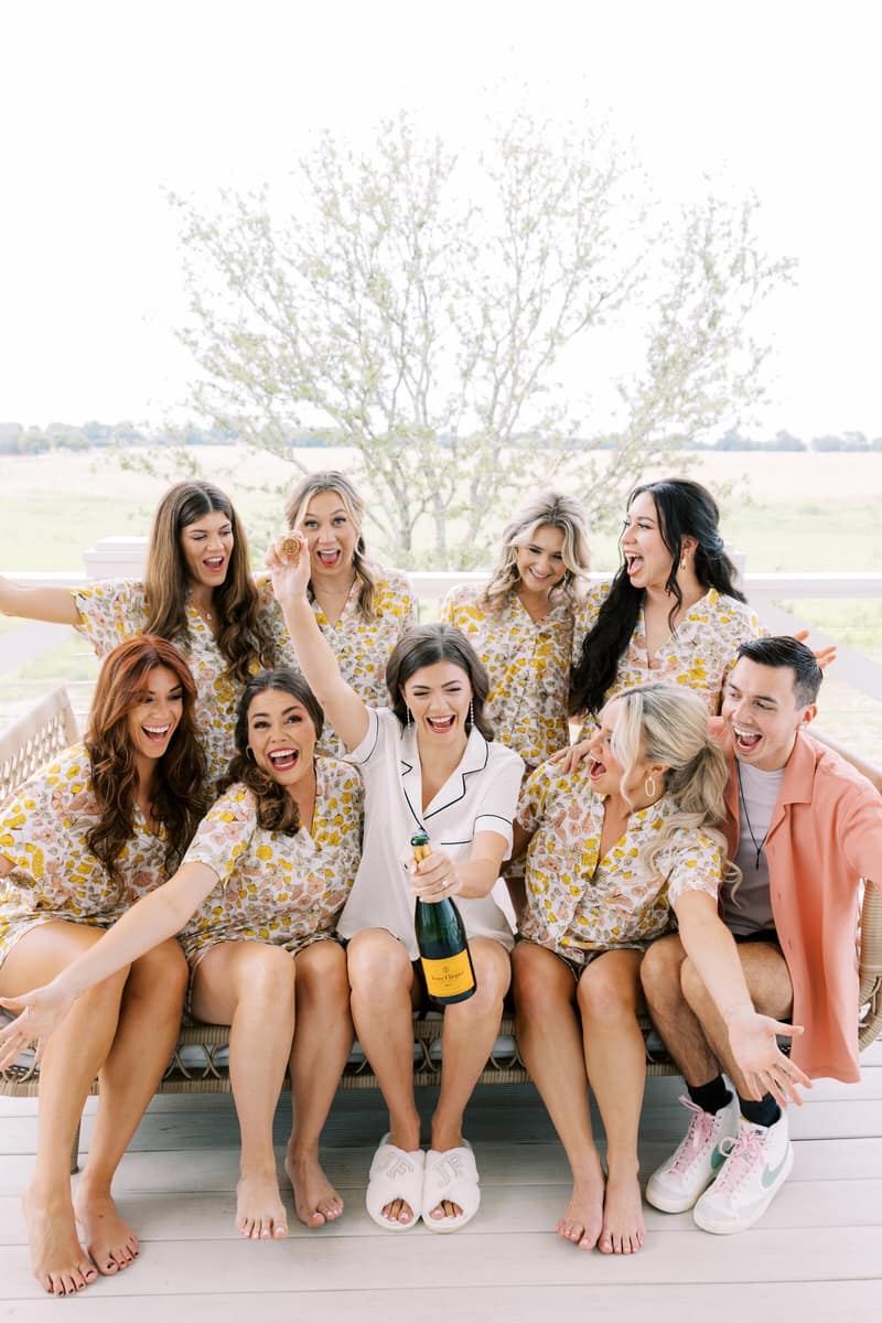 Bridal party in matching pajamas with champagne before the ceremony